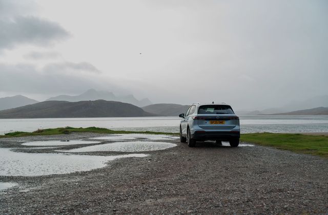 A car parked by a mountain lake